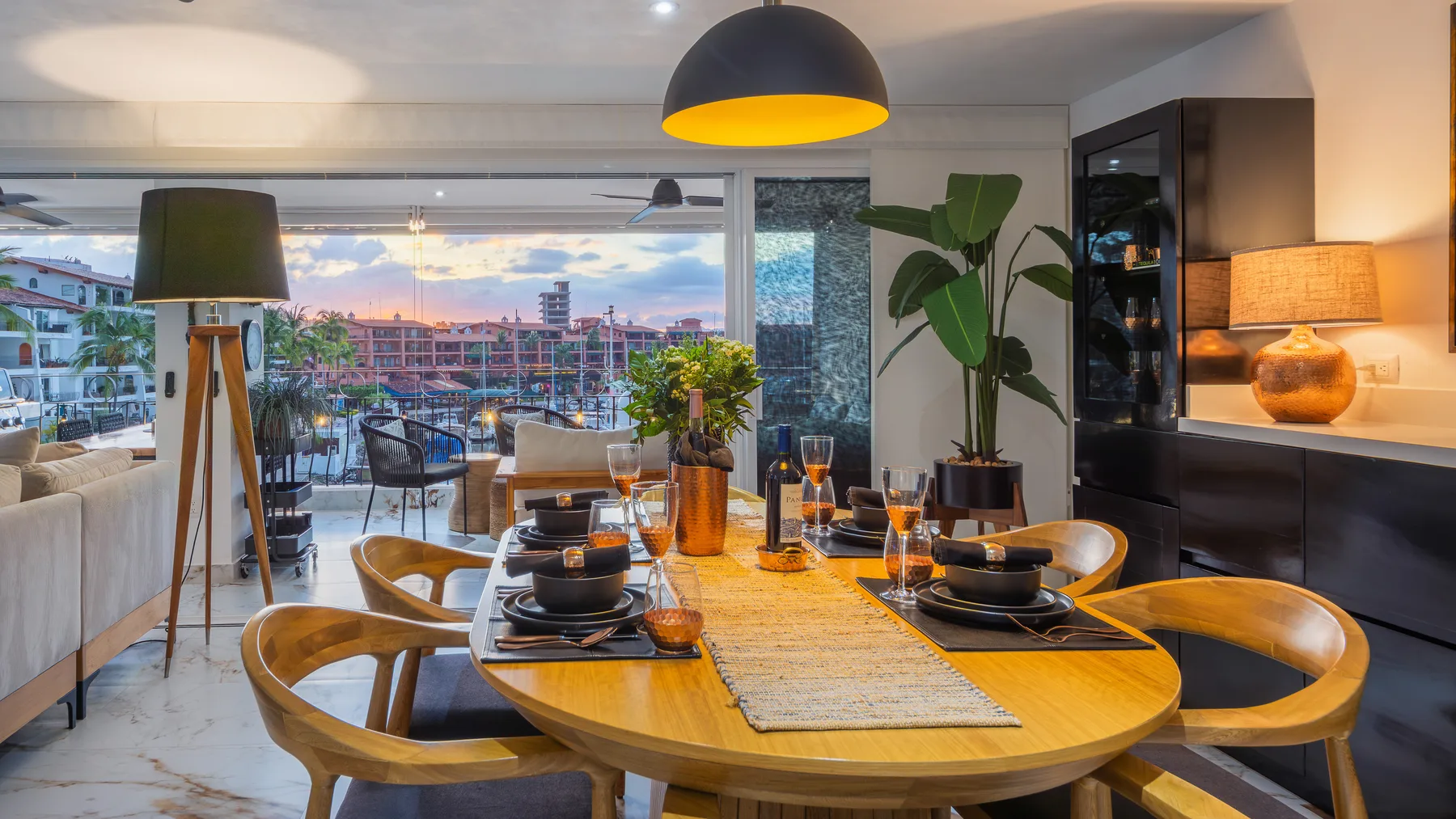 Dining table set for six with the marina through the open wall