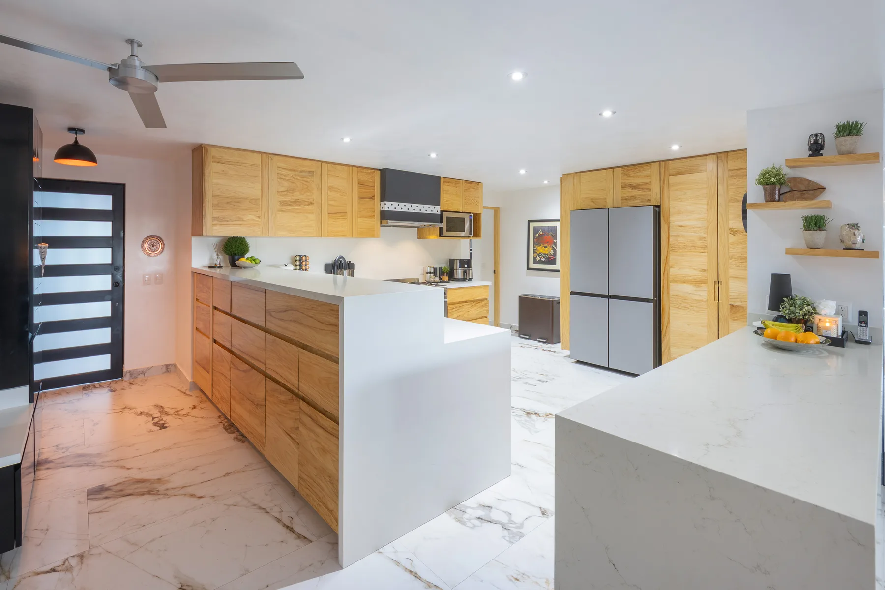 Renovated kitchen with waterfall quartz island and custom wood cabinetry