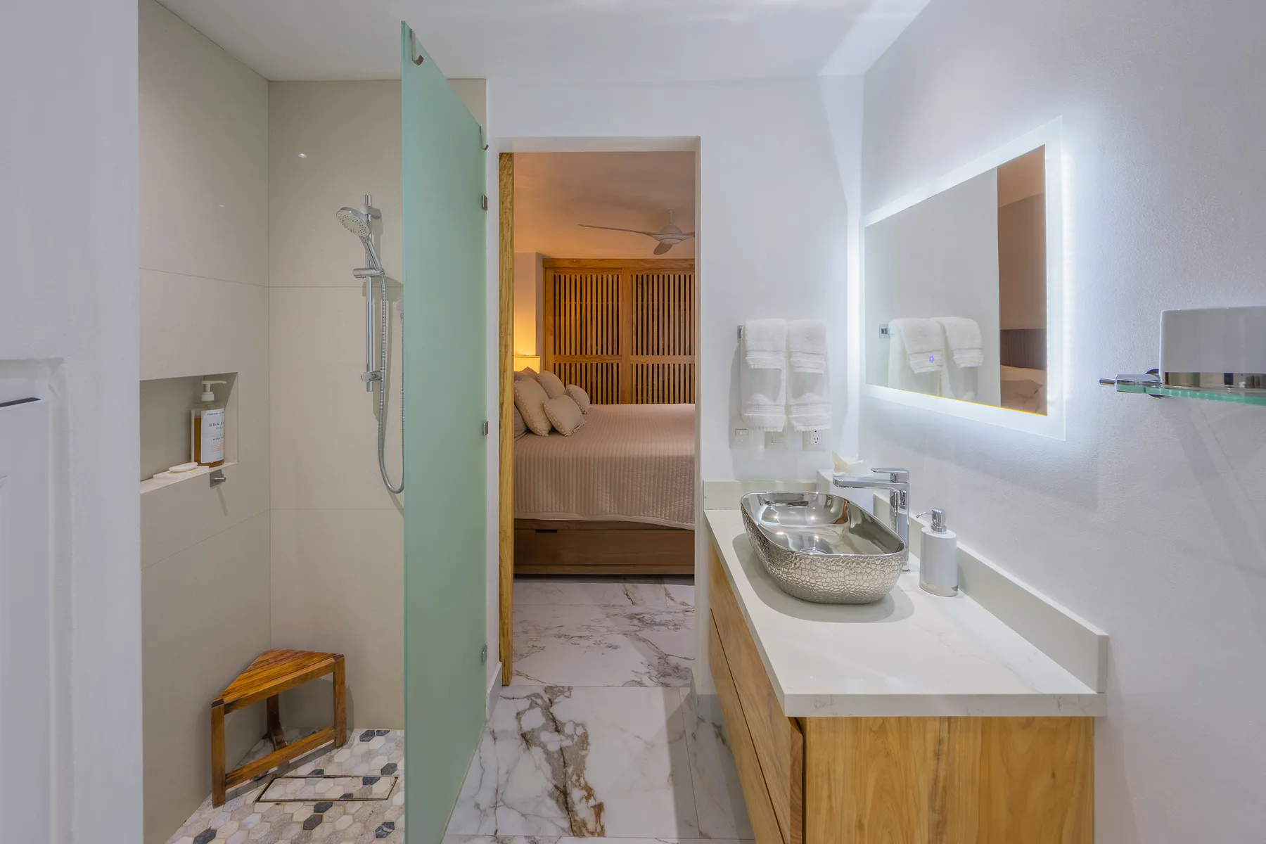 Ensuite vanity with backlit mirror opening to the bedroom