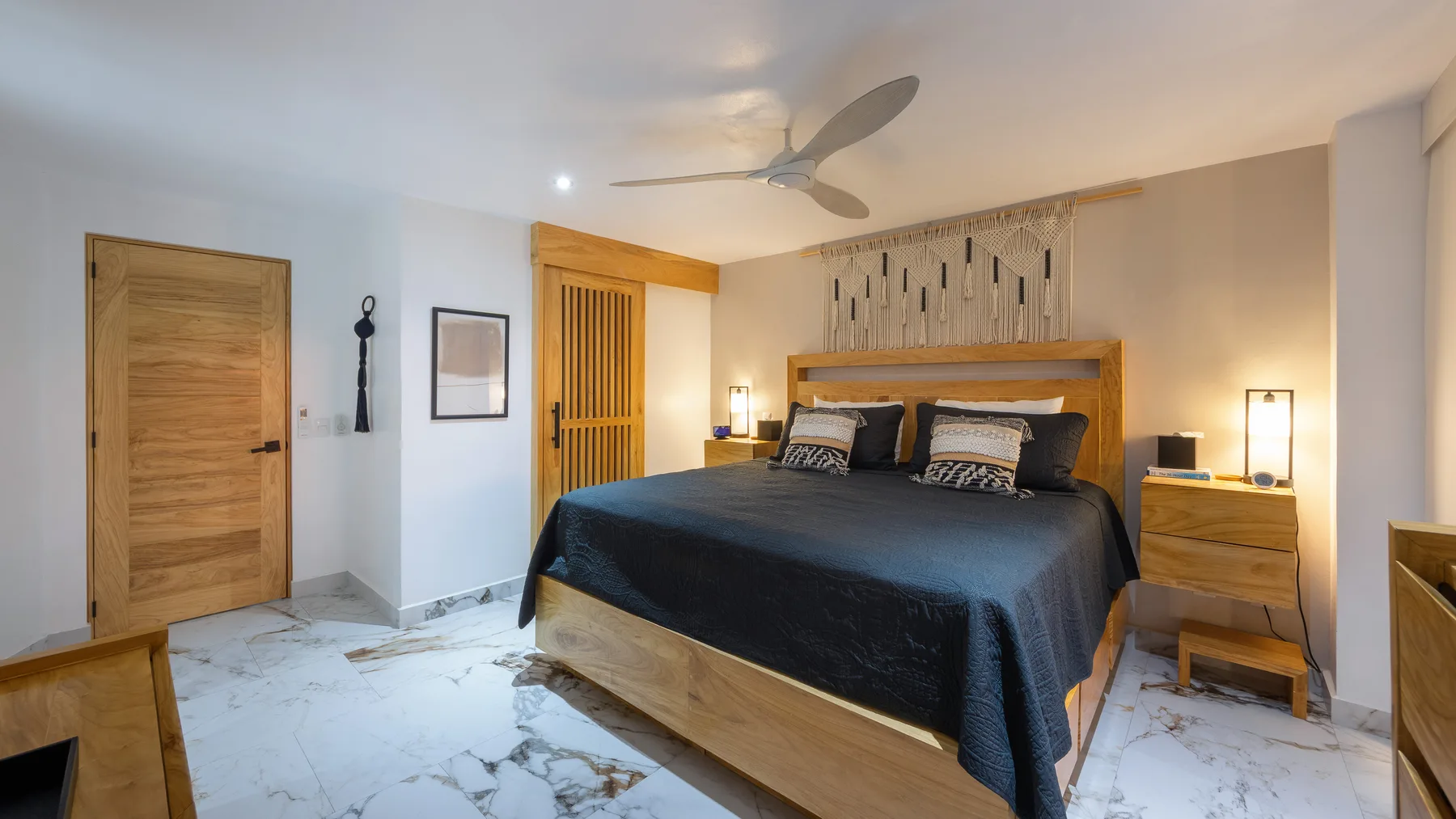 Primary bedroom with carved wood headboard and reading lamps