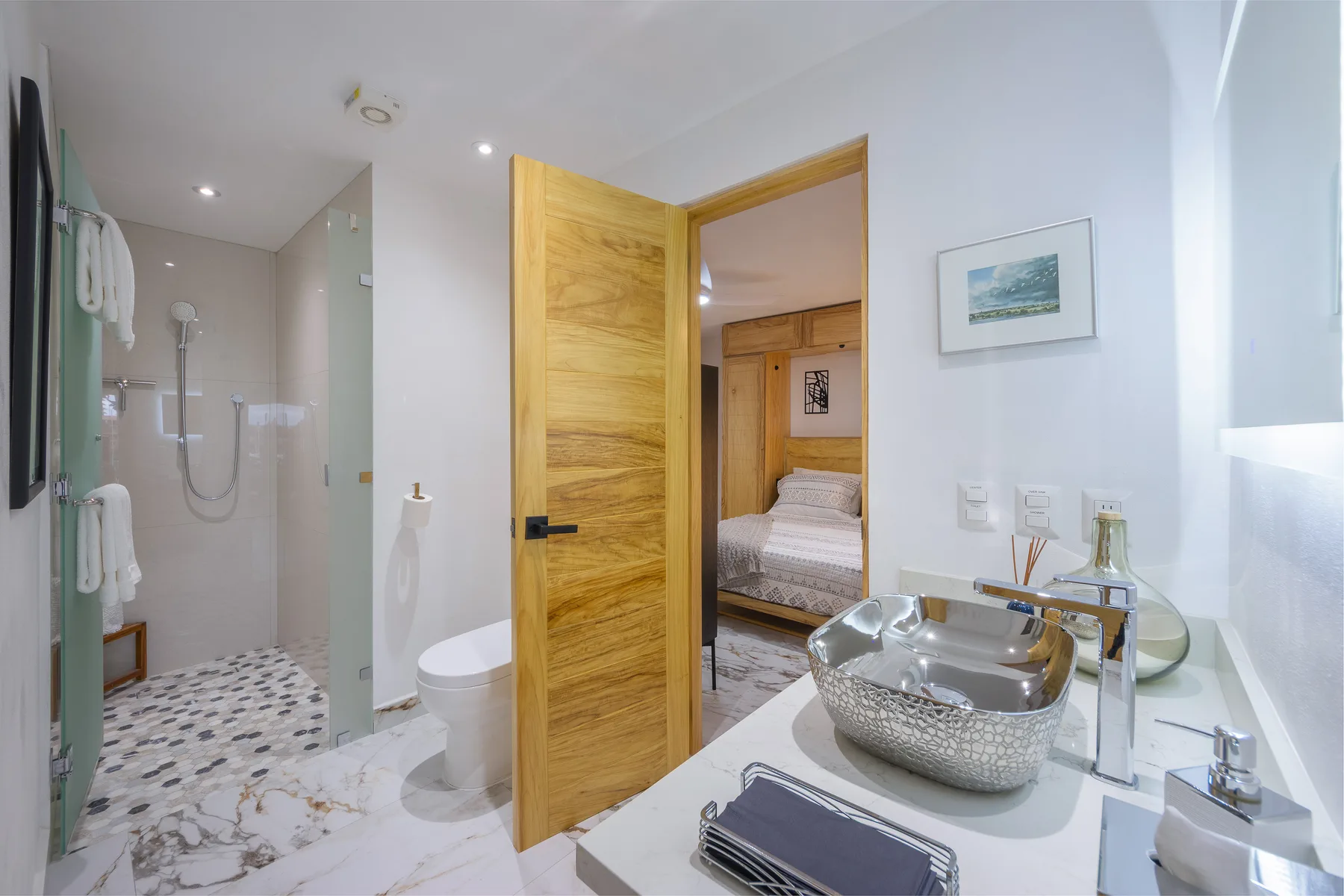 Bathroom with hammered vessel sink opening to a bedroom